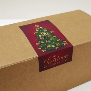 Brown kraft gift box sealed with a red Christmas tree sticker saying Merry Christmas