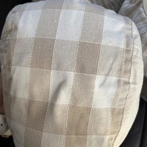 Close-up of the breathable linen gingham fabric texture and stitching on the newsboy cap