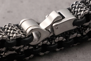 Macro shot of polished stainless steel clasp on a black braided leather bracelet for men