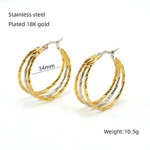 Detail of 34mm multi-layer twisted hoop earrings in gold and silver stainless steel