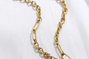Dettaglio della collana a cuore dorata con maglie ovali e rettangolari stile graffetta