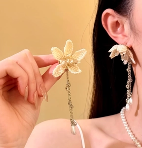 Detail view of French-style floral beaded earrings with long pearl tassels