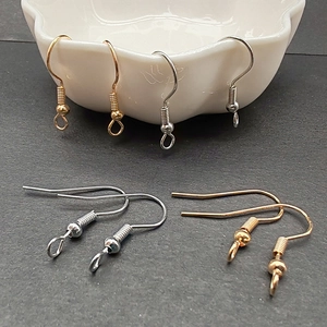 Detalle de ganchos para pendientes DIY dorados y plateados con diseño de muelle y bola