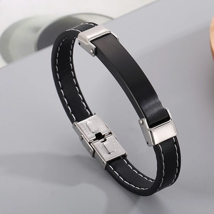 Detail of black leather men's bracelet with white stitching and stainless steel clasp