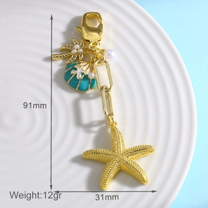Detailed macro view of starfish and seashell keychain charms with measurements on a tray