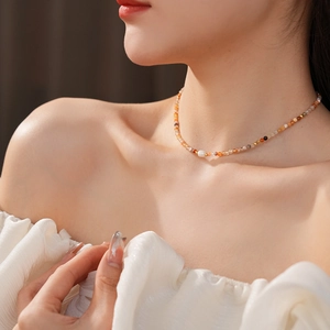 Macro shot of colorful beaded choker with freshwater pearl on a female model's neck