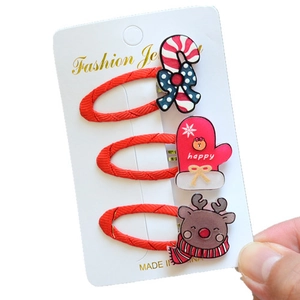 Detailed view of Christmas hair clip set featuring candy cane, glove, and reindeer motifs
