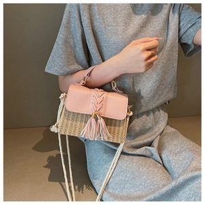 Detail of straw woven bag with pink PU leather flap and white rope strap on model