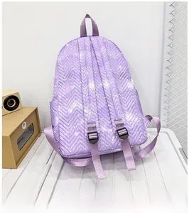 Vista detallada de mochila morada con costuras en chevron y estampados de corazones