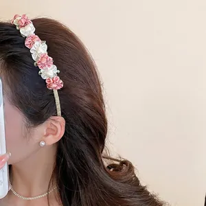 Elegant satin flower headband in pink and white fabric on a slim gold metal band