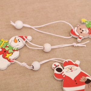 Detailed view of handmade wooden Christmas ornaments with Santa and snowman on linen fabric
