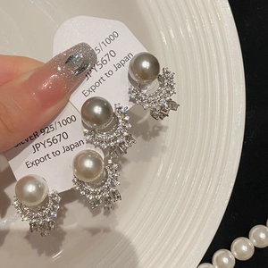 Detail of 925 silver pearl earrings with zircon crescent moon and delicate tassels