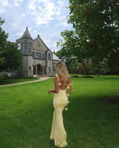 Détail de la robe dos nu jaune clair avec des fleurs 3D délicates sur les bretelles