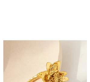 Detail eines goldenen Blumenrings mit Schichtblättern und einem strukturierten Band