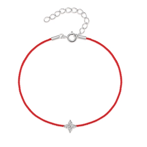 Detail of red string bracelet with silver four-petal flower charm and zircon stones