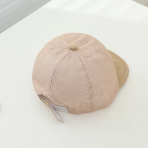 Macro shot of the breathable mesh texture and adjustable back strap on the beige baby cap