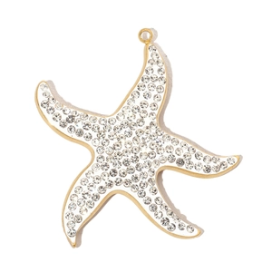 Macro shot of a gold-plated starfish pendant with sparkling rhinestones and shiny finish