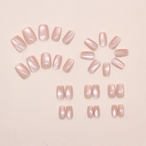 Flat lay of nude pink cat-eye press-on nails in various sizes for a sweet daily look