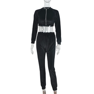 Dettaglio del tessuto in velluto nero sul completo con crop top e pantaloni sportivi