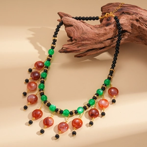 Close-up of ethnic tassel necklace with multicolored resin beads and adjustable gold clasp