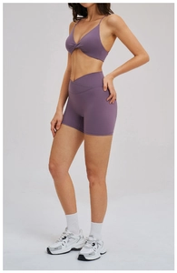 Detail of purple yoga set featuring a twisted sports bra and cross high-waisted shorts