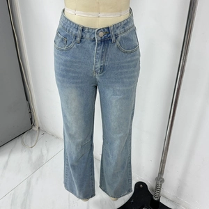 Detailed close-up of light blue vintage straight-leg denim jeans with heavy wash texture