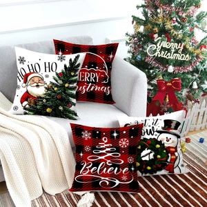 Set of 4 Christmas pillow covers with red plaid and festive motifs on a sofa