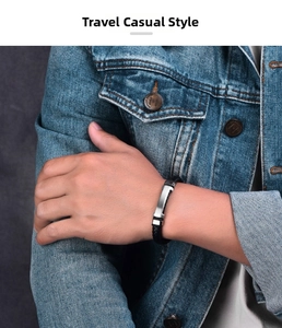 Close-up of a men's black braided leather bracelet with a polished stainless steel metal plate