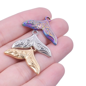 Detailed close-up of gold, silver, and rainbow stainless steel whale tail pendants