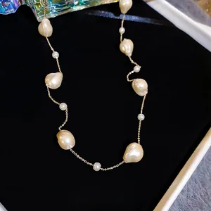 Elegant gold-plated pearl choker necklace featuring baroque and round beads on black velvet