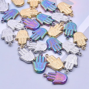 Vue macro des pendentifs Main de Fatma en or argent et arc-en-ciel pour bijoux DIY