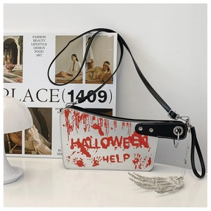 Detail of cleaver shaped Halloween crossbody bag with skeleton charm and adjustable strap