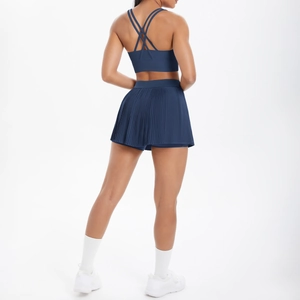Détail d'un ensemble de sport bleu foncé avec brassière dos croisé et jupe plissée