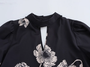 Detail of vintage floral print blouse with cut-out high neck and lantern sleeves in black