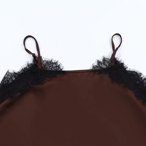 Détail macro du caraco en soie marron avec bordure en dentelle noire et col en V