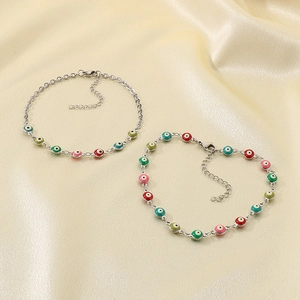 18K gold plated stainless steel evil eye anklets with colorful beads on silk background