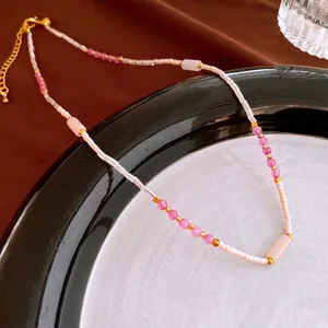 Vintage beaded necklace with pink natural stones and gold accents on a ceramic plate