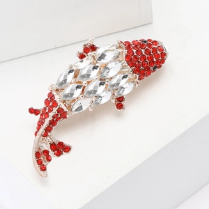 Elegant gold-tone fish brooch with red and clear rhinestones on a clean studio background