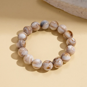 Detailed view of beaded bracelet with brown and white marble texture on warm background