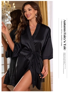 Detail of black satin robe with silk texture and elegant tassel belt fringe