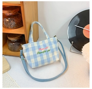 Detail of blue checkered canvas kids bag with Happy Girl pink embroidery and strap