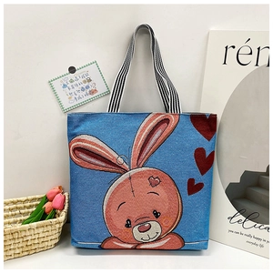 Detail view of cartoon rabbit tote bag with striped handles and linen canvas texture