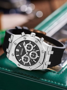 Macro shot of silver stainless steel chronograph watch with textured black dial and strap