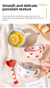 Close-up of hand-painted ceramic mugs and heart spoon on cozy knit background