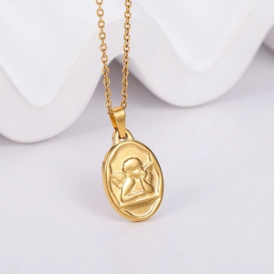 Detail view of a gold oval Cupid pendant necklace with fine angel embossing on a white background