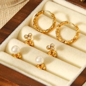 Detailed set of hammered titanium steel hoops, zircon studs, and white pearl earrings