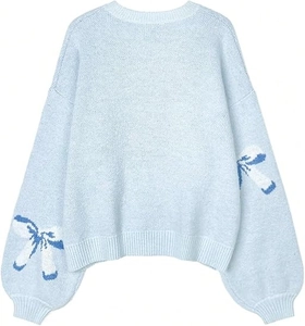 Detail of light blue knit sweater featuring navy and white bow jacquard on long sleeves