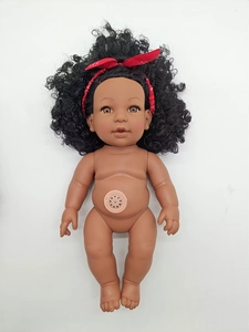 Detailed view of black baby doll's abdominal music speaker device on a white background