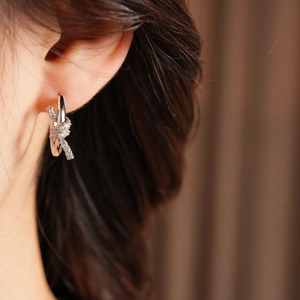 Macro view of 18k gold plated knot earrings with shimmering pavé micro-zirconia stones