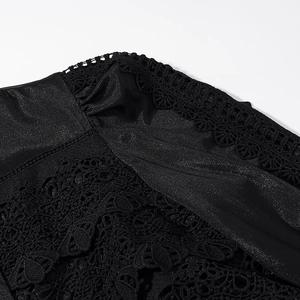 Detail of elegant black lace crochet stitching on smooth satin fabric for a chic dress